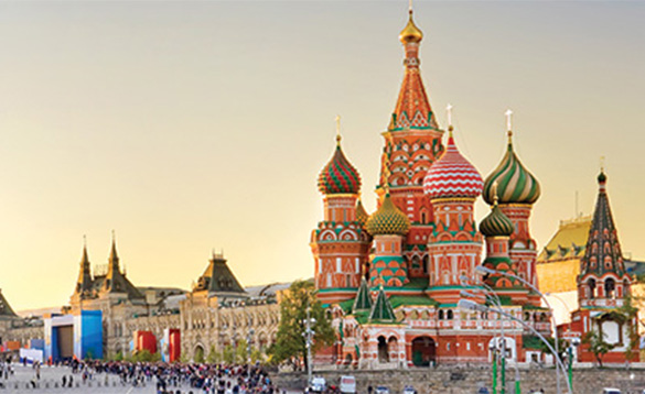 multicoloured orange and green buildings with striped muticoloured domed roofs in middle eastern city/