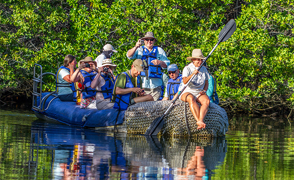 group of people on an inflatable boat travelling along a river/