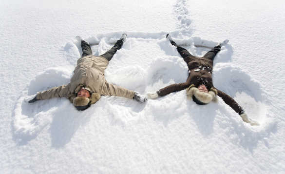 Couple making snow angels in Finnmark/
