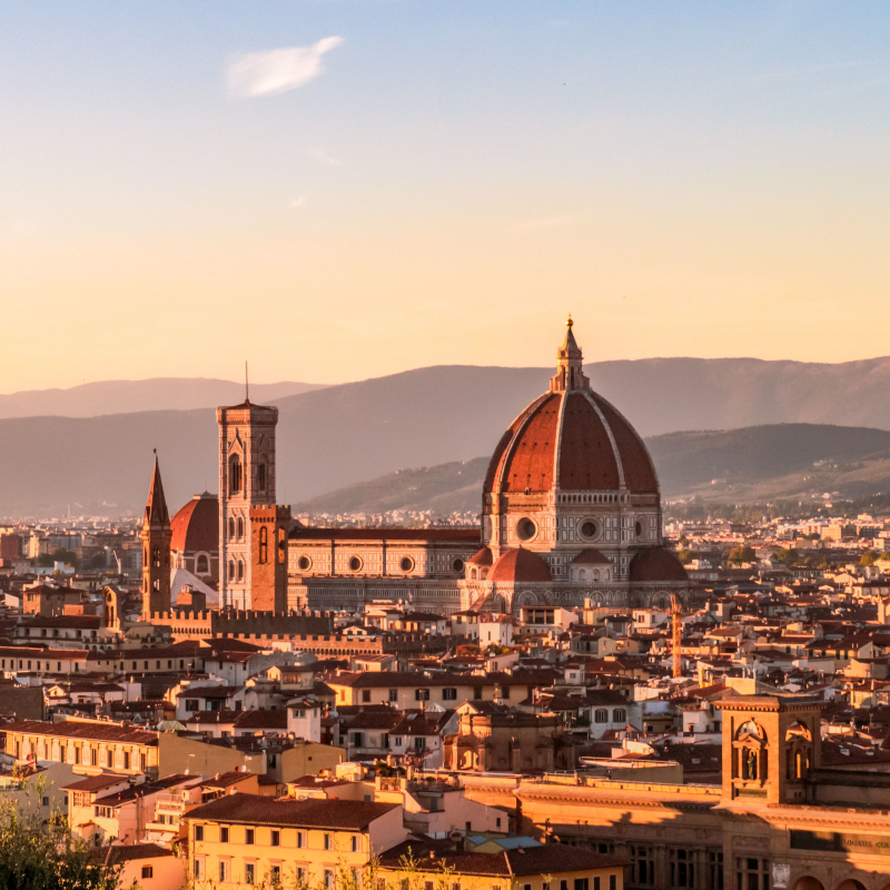 Panoramic view of Florence featuring the iconic Florence Cathedral and cityscape at sunset.